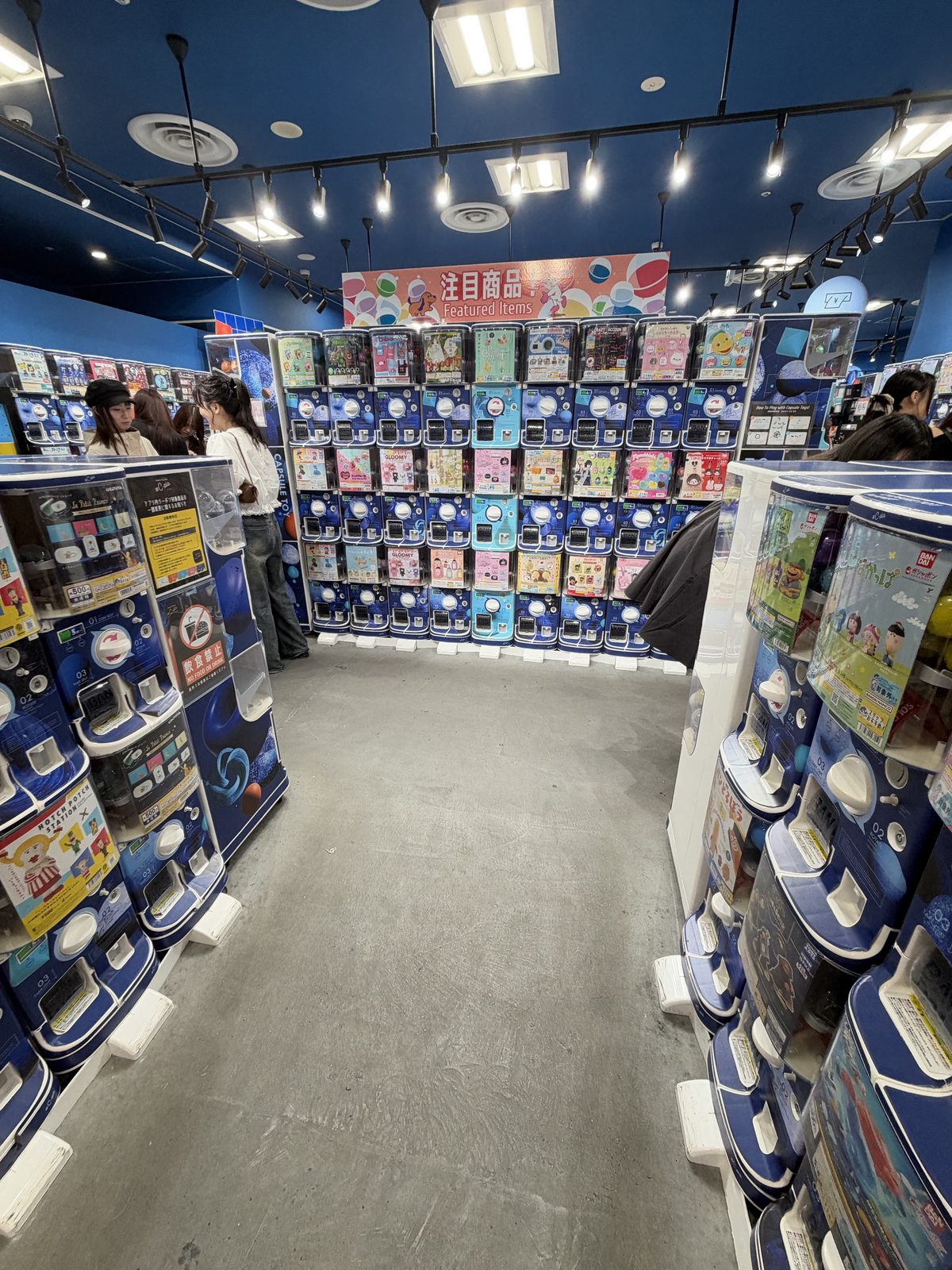 A capsule toy shop with machines along every wall, photographed in October 2026.