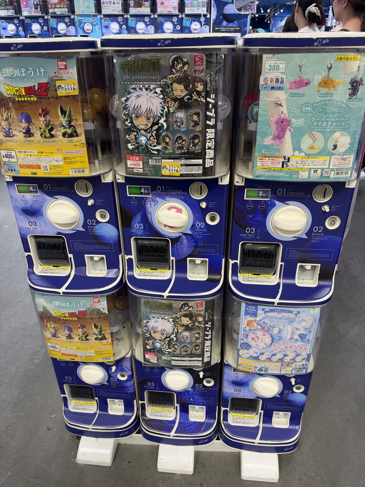 Capsule toy machines, each showing its series on the front, photographed in October 2026.