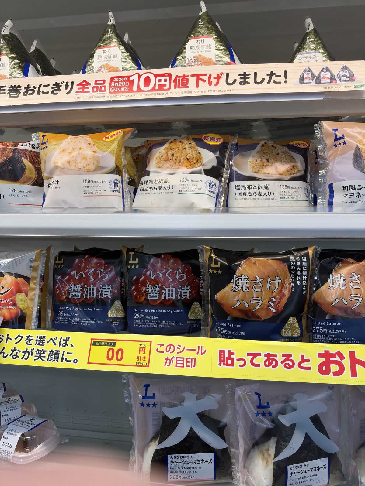 The rice ball shelf, photographed on 7 October 2026. The yellow strip marks a 10-yen reduction across the range.